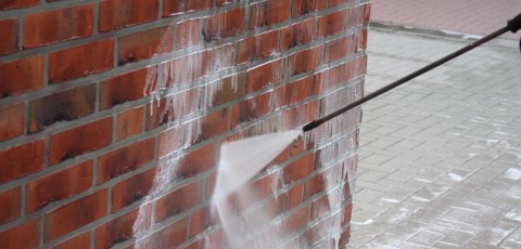 An image showing shot blasting techniques used to remove graffiti from a wall