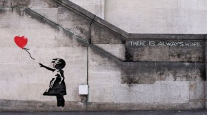 An image showing building art by artist Banksy depicting a little girl letting go of a heart balloon