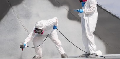 an image of two workers powder coating a piece of metal
